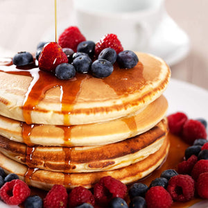 Une pile de crAapes moelleuses garnies de myrtilles fraARches, de framboises et arrosACes de sirop, suggACrant un dAClicieux petit-dACjeuner ou brunch.