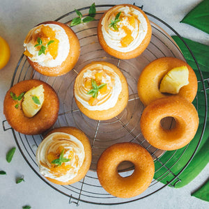 Une sAClection de beignets dorACs, certains garnis de crA?me et de fruits, disposACs sur une grille.