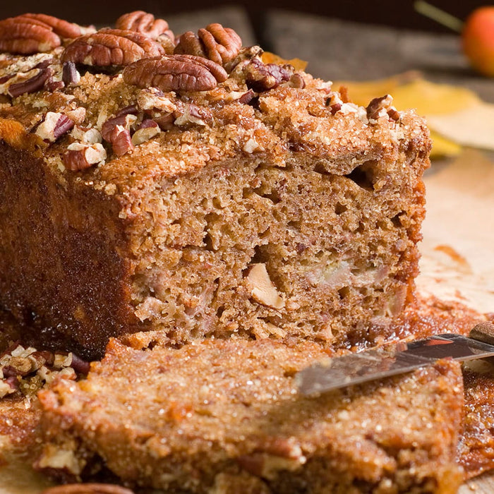 Une tranche de pain aux noix de pACcan est coupACe, mettant en valeur sa texture moelleuse et sa garniture aux noix.