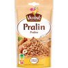 Un paquet de Vahiné Pralin présentant un tas de morceaux de pralin avec des noisettes et des amandes.