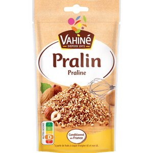 Un paquet de Vahiné Pralin présentant un tas de morceaux de pralin avec des noisettes et des amandes.