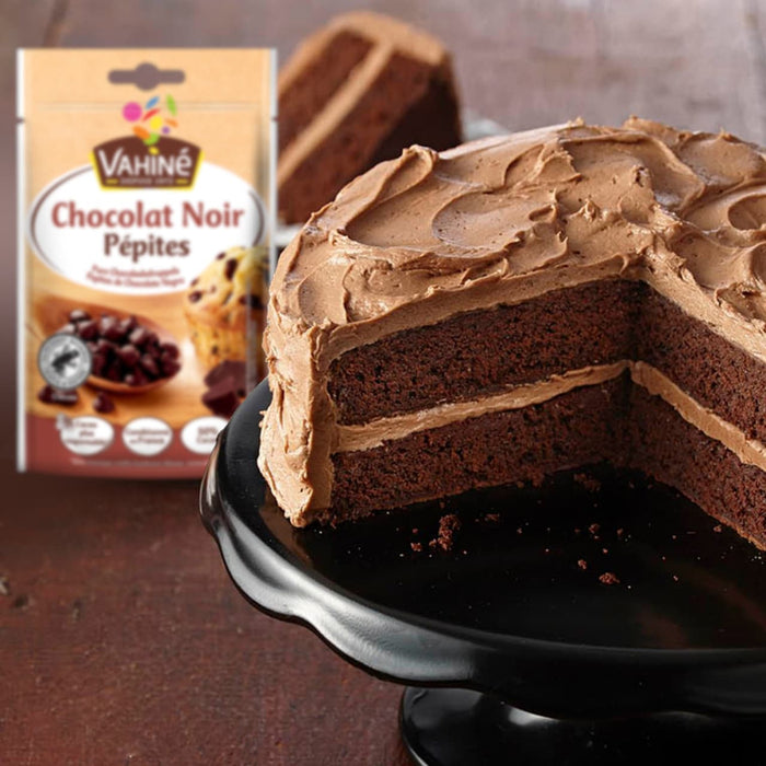 Une pile de sandwichs glacés aux biscuits aux pépites de chocolat faits maison avec des vermicelles, à côté d'un sac de pépites de chocolat noir Vahiné et d'un récipient de vermicelles.