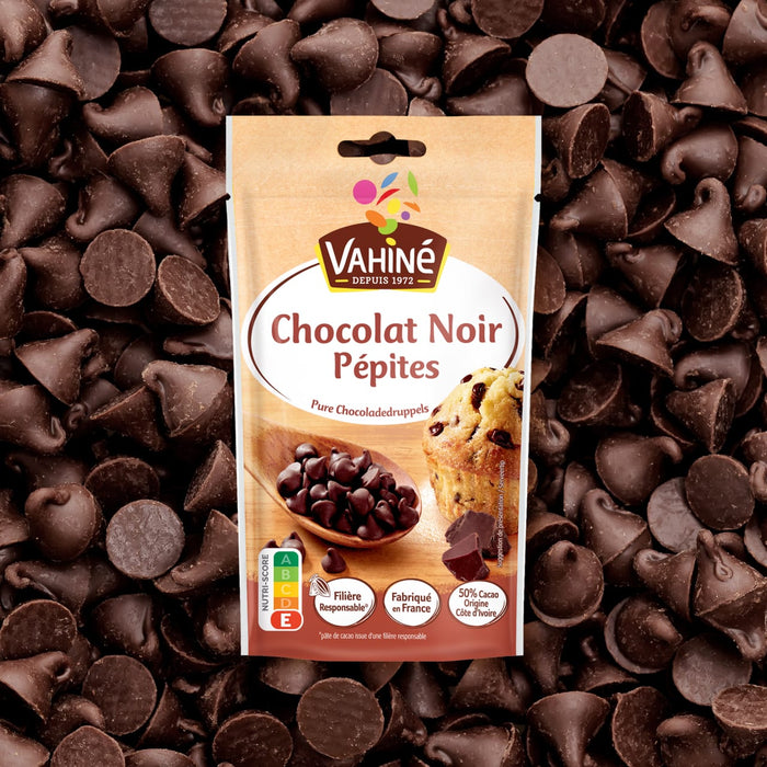 Un sac de pépites de chocolat noir Valhrona est présenté au milieu d'une dispersion des mêmes pépites de chocolat.