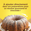Un délicieux gâteau aux pépites de chocolat saupoudré de sucre glace, suggérant que le produit peut être ajouté directement aux préparations pour un résultat gourmand et chocolaté.