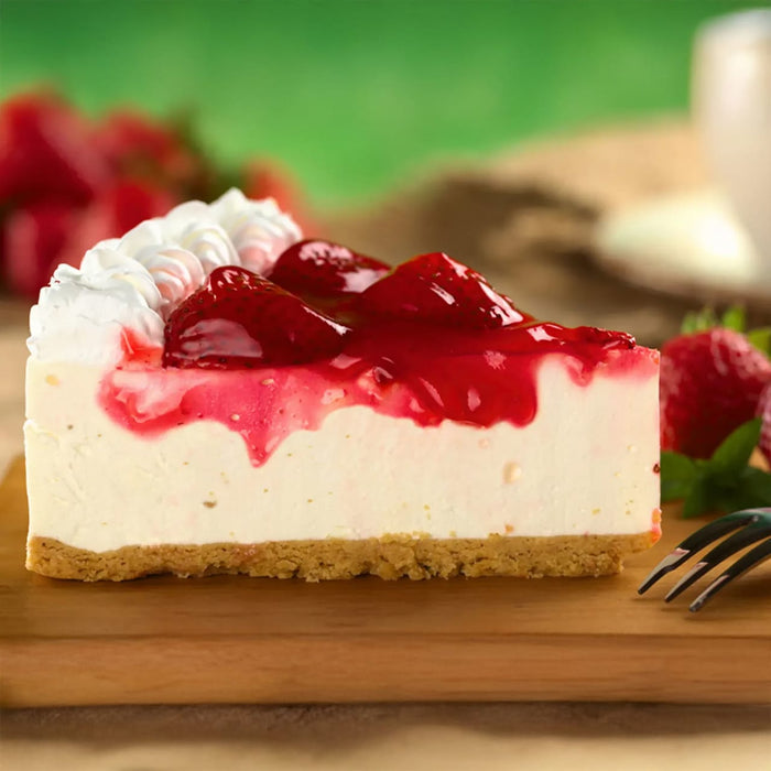 Une part de gActeau au fromage crACmeux garnie de fraises fraARches et de crA?me fouettACe sur une planche en bois.