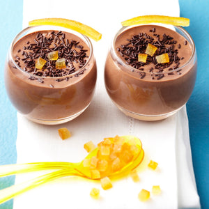 Deux verres de mousse au chocolat garnis de vermicelles au chocolat et d'ACcorces d'orange confites, prACsentant un dessert dACcadent.