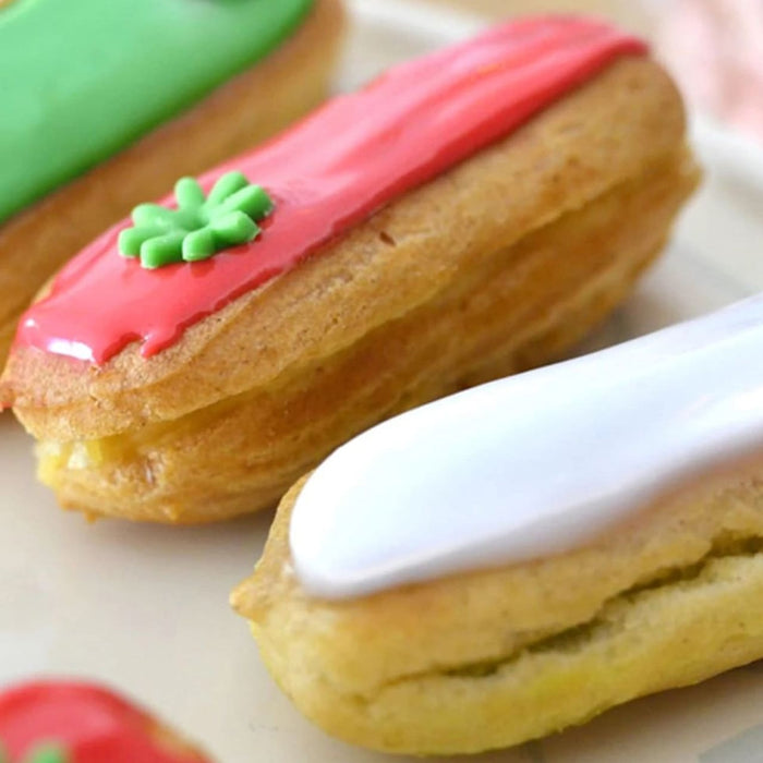 Gros plan sur des éclairs colorés avec différents glaçages aromatisés.