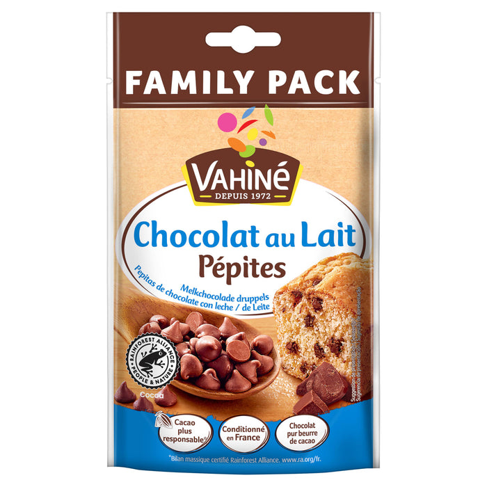 Un sachet Family Pack de Vahiné Chocolat au Lait Pépites avec une cuillère en bois remplie de pépites de chocolat au lait et un muffin aux pépites de chocolat.