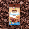 Un paquet familial de pépites de chocolat au lait Vahiné est présenté sur un fond de pépites de chocolat éparpillées.