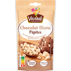 Un paquet de pépites de chocolat blanc Vahiné, une marque McCormick, est présenté à côté d'un biscuit aux pépites de chocolat.