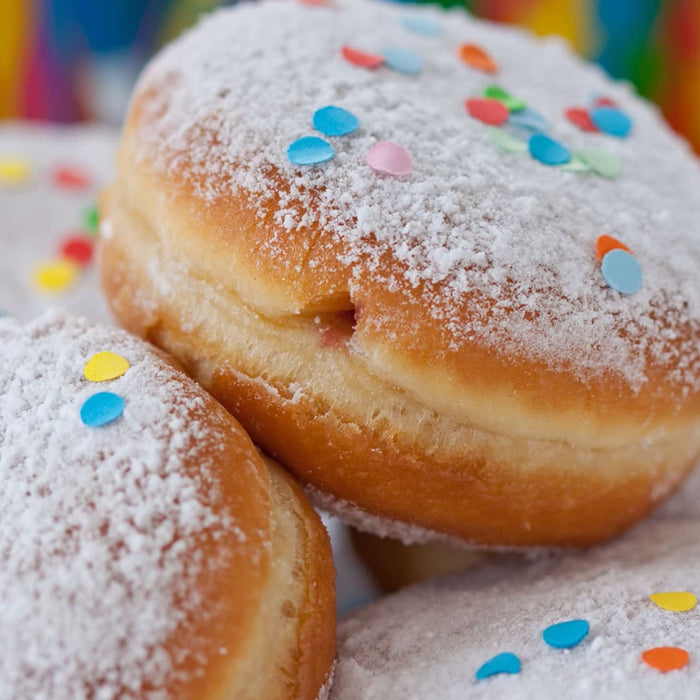 Une pile de beignets saupoudrACs de sucre glace et de confettis colorACs, parfaits pour une cAClACbration festive.