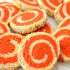 Une pile de biscuits tourbillons colorACs avec un tourbillon de pActe rouge et blanche et des vermicelles sur les bords.