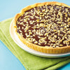 Une dAClicieuse tarte au chocolat garnie de graines de tournesol est posACe sur une assiette avec une serviette verte.