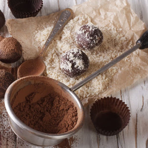 Une prise de vue rapprochACe de truffes au chocolat faites maison avec de la poudre de cacao et de la noix de coco rAcpACe, suggACrant une gActerie dAClicieuse et gourmande.