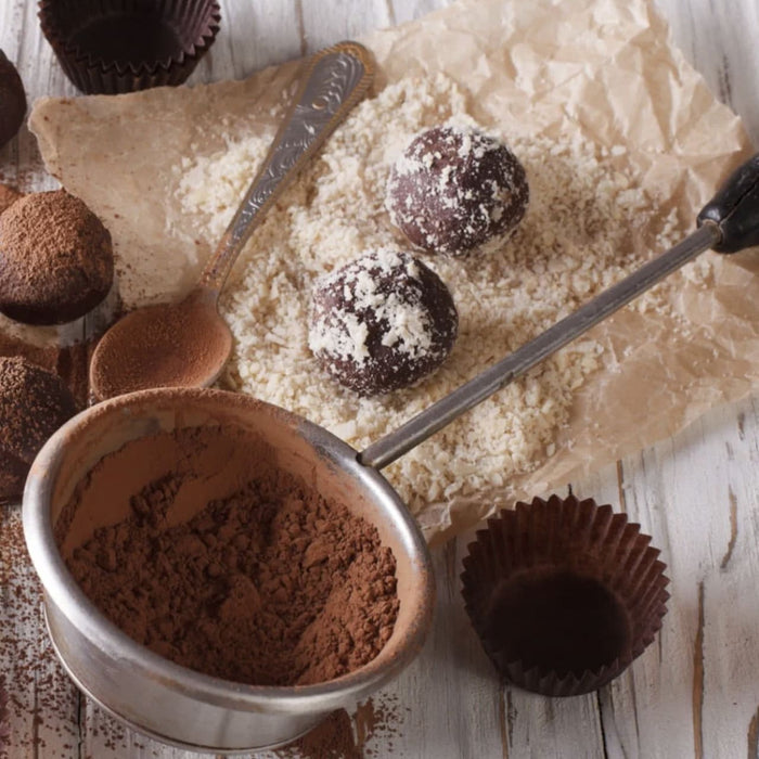 Une prise de vue rapprochACe de truffes au chocolat faites maison avec de la poudre de cacao et de la noix de coco rAcpACe, suggACrant une gActerie dAClicieuse et gourmande.