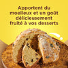 Un cake aux fruits coupé sur une planche en bois, mettant en valeur sa texture moelleuse et son goût délicieusement fruité.