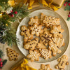 Un arrangement festif de biscuits au pain d'ACpices de diffACrentes formes, comme des flocons de neige, des bonhommes en pain d'ACpices et des sapins de NoA<l, dACcorACs de glaA?age blanc, entourACs de dACcorations de NoA<l.