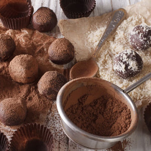 Un assortiment de truffes au chocolat est prACsentAC avec de la poudre de cacao et de la noix de coco rAcpACe.