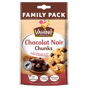 Un sachet Family Pack de Vahiné Chocolat Noir Chunks présentant une cuillère en bois remplie de pépites de chocolat noir et un biscuit aux pépites de chocolat.