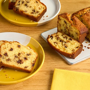 Des tranches de cake aux pACpites de chocolat sont disposACes sur des assiettes colorACes, prACsentant une dAClicieuse gourmandise faite maison.