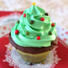 Un cupcake festif en forme de sapin de Noël avec un glaçage vert, des décorations colorées et une étoile sur le dessus.