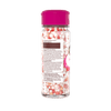Une bouteille de vermicelles de dACcoration avec un couvercle rose, probablement utilisACe pour dACcorer des desserts.