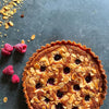 Une tarte aux amandes et aux fruits rouges d'aspect dAClicieux avec des amandes grillACes sur un fond sombre, suggACrant un dessert fait maison.