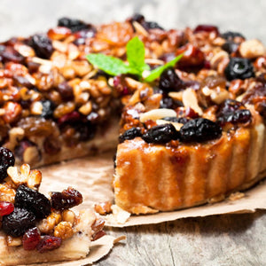 Une tarte aux fruits et aux noix d'aspect dAClicieux avec une tranche coupACe, mettant en valeur sa garniture riche.
