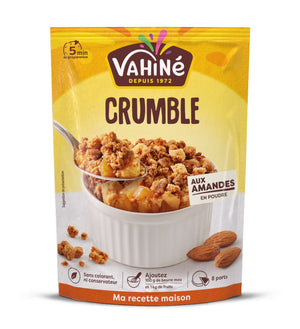 Un sachet de préparation pour crumble de la marque Vahiné est présenté avec une portion de crumble fini dans un ramequin blanc.