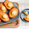 Des madeleines dorées sont artistiquement disposées sur une assiette bleue, présentant une délicieuse recette de la collection Vahine Nutritional Ingredients And Hero Recipe Images.