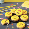 Une collection de biscuits sur le thA?me des emojis, avec un glaA?age jaune et une garniture au chocolat, sont disposACs sur une assiette, entourACs de confettis colorACs et de pailles, suggACrant une cAClACbration festive.