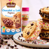 Cette image présente des pépites de chocolat au lait Vahiné à côté de biscuits colorés recouverts de vermicelles, mettant en évidence les ingrédients de pâtisserie et les friandises finies.