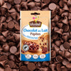 Un paquet de Vahine Sch Pepites Chocolaitx10-Va, présentant des Pépites de Chocolat au Lait Vahiné, est affiché sur un fond de pépites de chocolat au lait éparpillées.