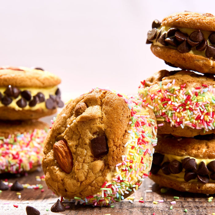 Une pile alléchante de sandwichs glacés aux biscuits, certains ornés de pépites de chocolat et d'autres de vermicelles colorés.