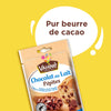 Un emballage Vahiné de pépites de chocolat au lait Vahine Sch Pepites Chocolaitx10-Va, étiqueté Pur beurre de cacao, est présenté à côté d'un muffin aux pépites de chocolat et d'une cuillère remplie de pépites.