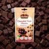 Un sachet de Vahiné Chocolat Noir Chunks est présenté sur un fond de carrés de chocolat noir.