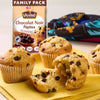 Des muffins aux pépites de chocolat fraîchement cuits sont présentés sur une serviette jaune, l'un d'eux étant cassé pour montrer l'intérieur moelleux, à côté d'un paquet familial de pépites de chocolat noir Vahine utilisées pour les préparer.