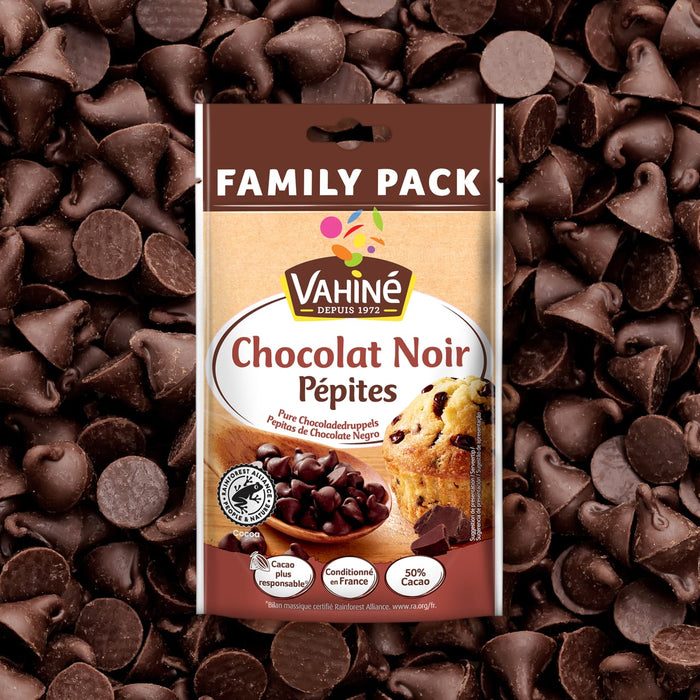 Un paquet familial de pépites de chocolat noir Vahiné est présenté sur un fond de pépites de chocolat éparpillées.