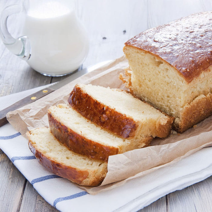 Une miche de quatre-quarts dorAC, tranchACe et servie avec un pichet de lait, suggA?re une gActerie rACconfortante et classique.