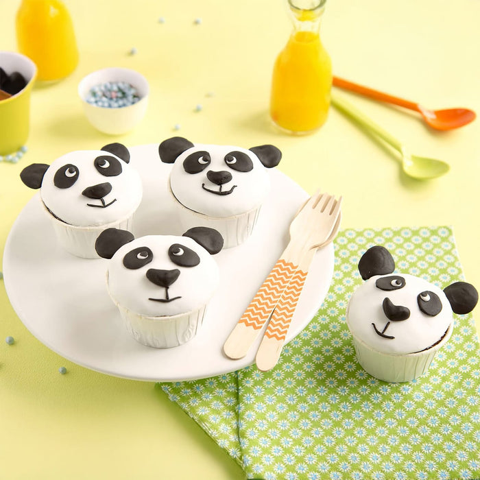 Une assiette de cupcakes sur le thA?me des pandas est posACe sur une table avec du jus et des ustensiles colorACs, parfaite pour une fAate d'enfants.