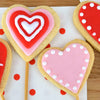 Une collection de biscuits sablACs en forme de cA?ur dACcorACs de glaA?age colorAC et certains sur des bActonnets de sucette, parfaits pour la Saint-Valentin.