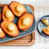 Une assiette de madeleines dorées avec une forme de coquille distinctive et une bosse caractéristique sur le dessus.