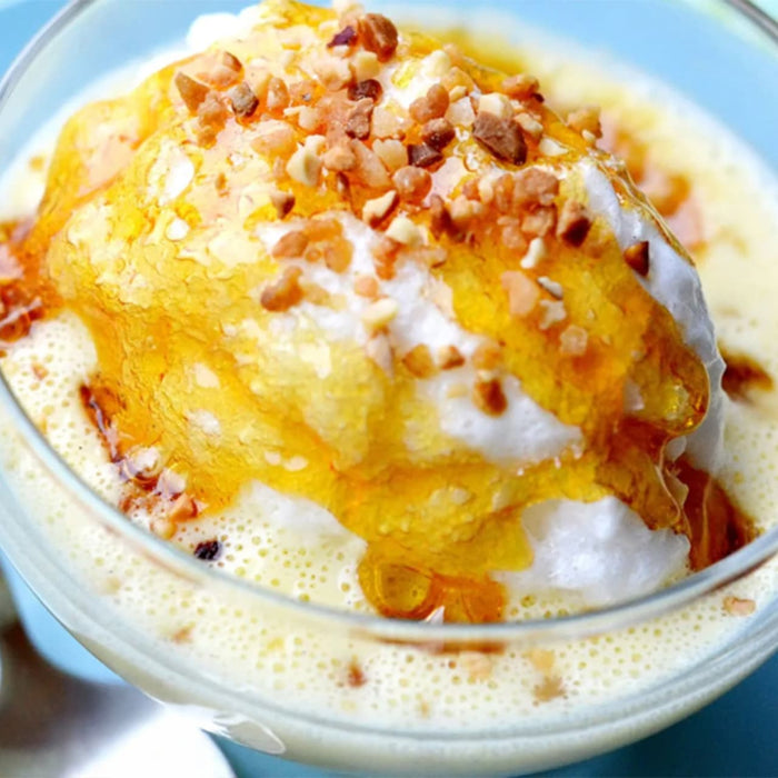 Gros plan sur une A?le flottante, un dessert composAC de meringue flottant sur une crA?me anglaise, nappACe de caramel et parsemACe de noix.