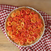 Une tarte visuellement attrayante prACsente une croA>te remplie d'une base crACmeuse et dACcorACe de tranches de lACgumes colorACes en spirale disposACes en forme de roses.
